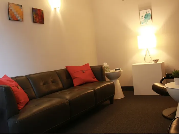 A counseling room with a long sofa, red cushions and two chairs