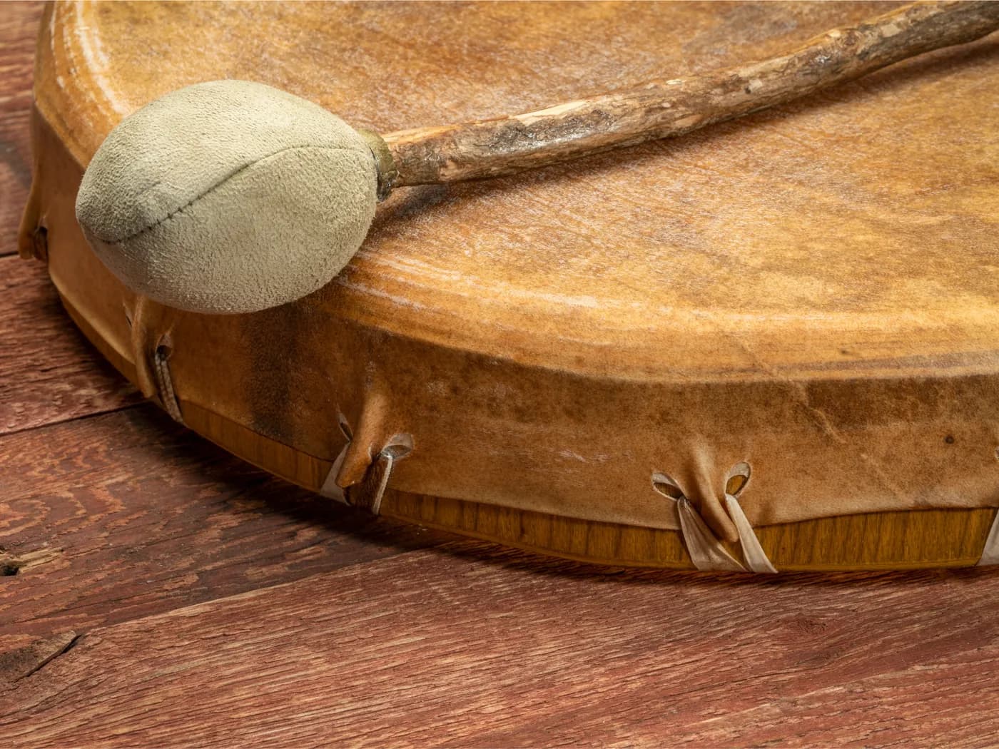 A padded mallet resting across a hand drum